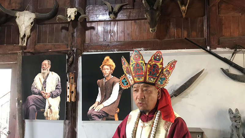A Naxi elder is introducing his home to visitors