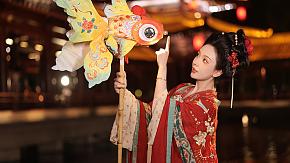 A girl holding a fish lantern in Tang Paradise